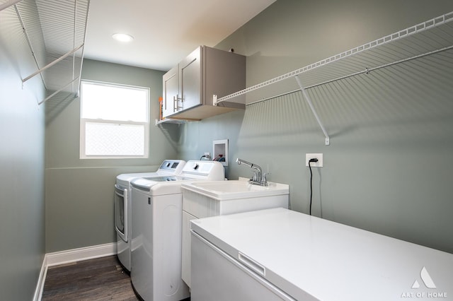 clothes washing area featuring cabinets, washing machine and dryer, and dark wood-type flooring