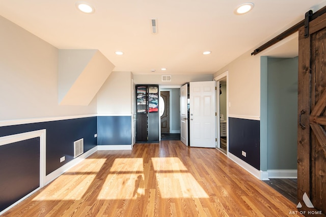 interior space featuring light wood-type flooring and a barn door