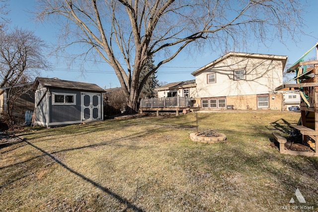 view of yard with a fire pit, a storage shed, and a wooden deck