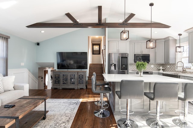 kitchen featuring gray cabinetry, hanging light fixtures, tasteful backsplash, lofted ceiling with beams, and stainless steel refrigerator with ice dispenser