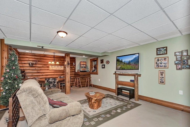 living room with bar area, a drop ceiling, and log walls