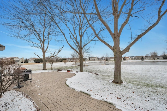 snowy yard featuring a patio area