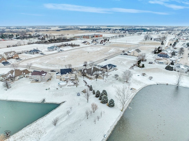 snowy aerial view featuring a water view