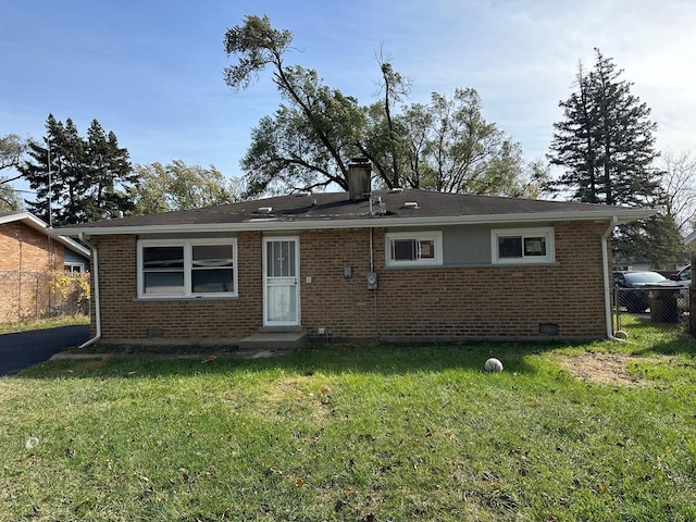 rear view of property featuring a lawn