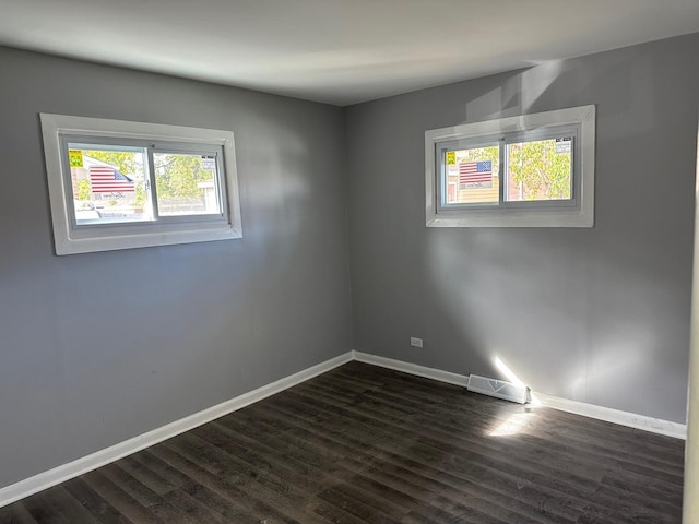 unfurnished room with dark hardwood / wood-style flooring