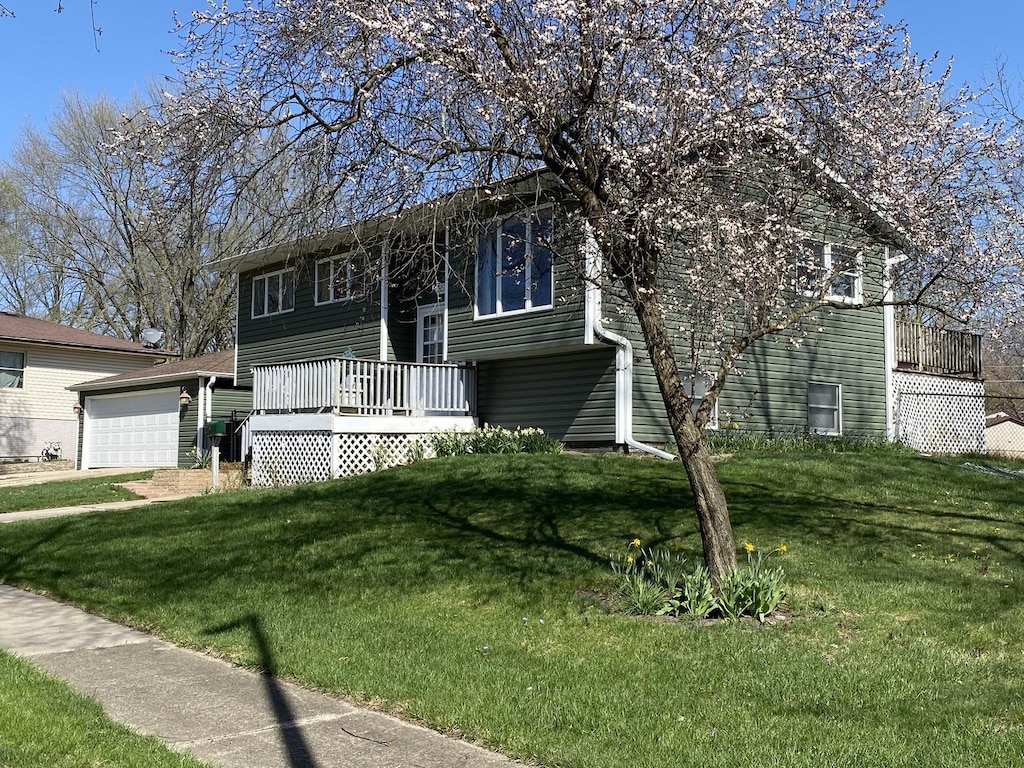 raised ranch featuring a wooden deck and a front lawn