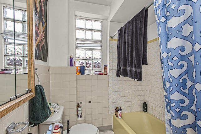 bathroom with shower / bath combination with curtain, tile walls, and toilet