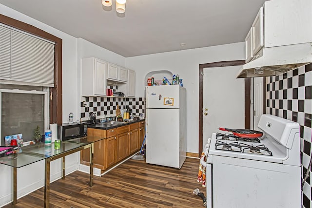 kitchen featuring white cabinetry, decorative backsplash, dark wood-type flooring, and white appliances