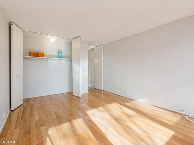 unfurnished bedroom featuring light hardwood / wood-style floors and a closet