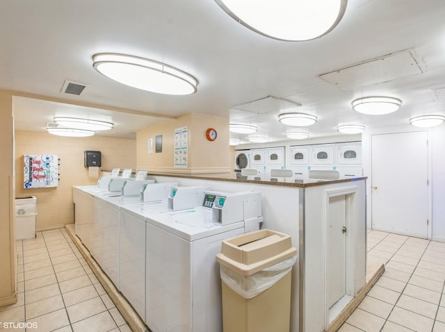 laundry room with washer and clothes dryer and light tile patterned flooring