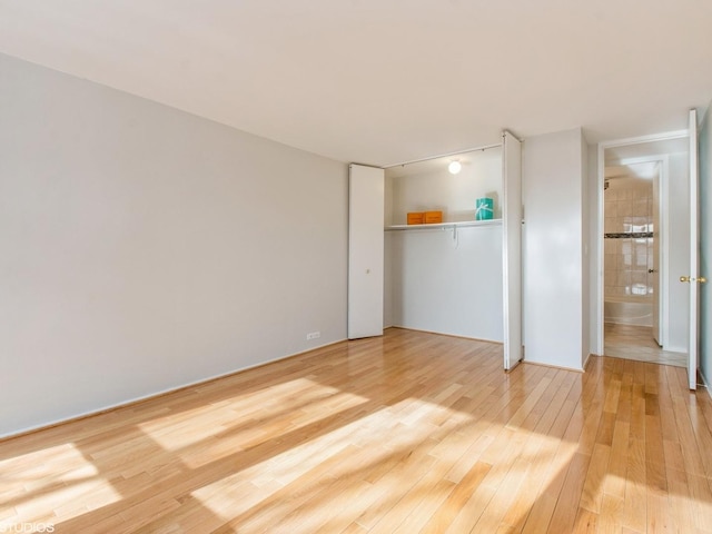 unfurnished bedroom with hardwood / wood-style flooring and a closet