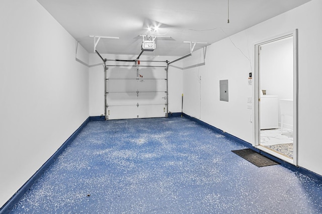 garage with electric panel, washer / clothes dryer, and a garage door opener