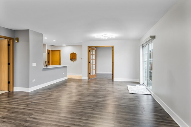 unfurnished living room with dark hardwood / wood-style floors, sink, and french doors