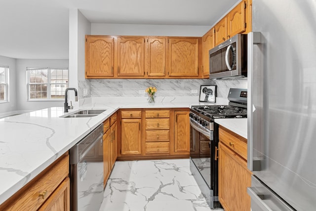 kitchen with decorative backsplash, sink, light stone counters, and stainless steel appliances