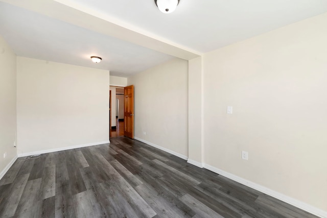 spare room featuring dark wood-type flooring