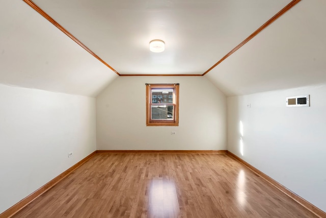 bonus room with lofted ceiling and light wood-type flooring