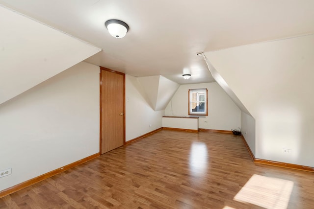 additional living space with hardwood / wood-style flooring and lofted ceiling