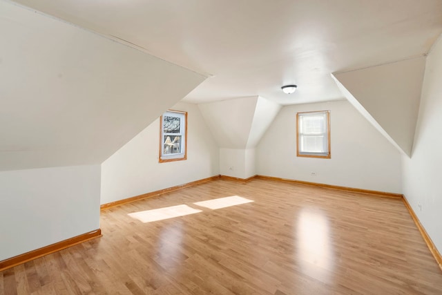 bonus room with vaulted ceiling and light hardwood / wood-style flooring