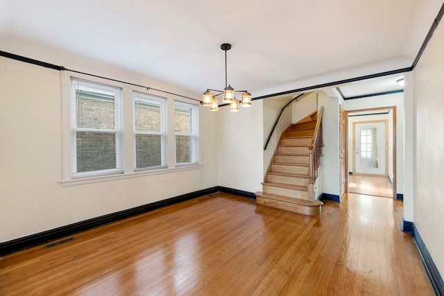 interior space with wood-type flooring, crown molding, and a chandelier