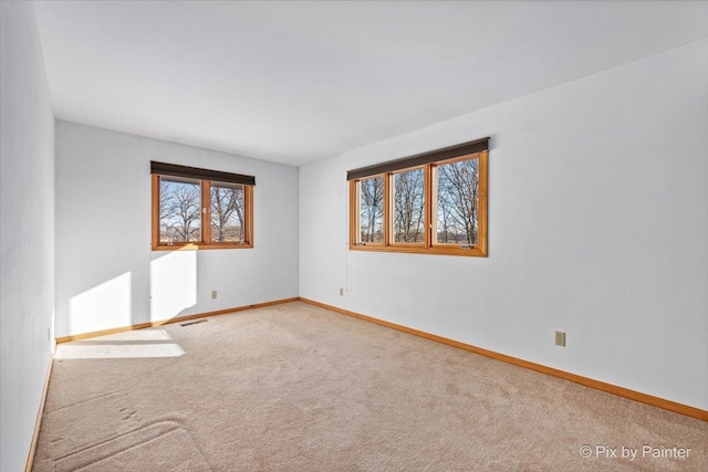 carpeted spare room featuring a healthy amount of sunlight