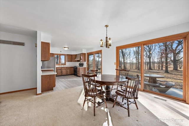 carpeted dining area with sink and an inviting chandelier