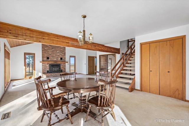 carpeted dining space with a notable chandelier, vaulted ceiling with beams, and a fireplace