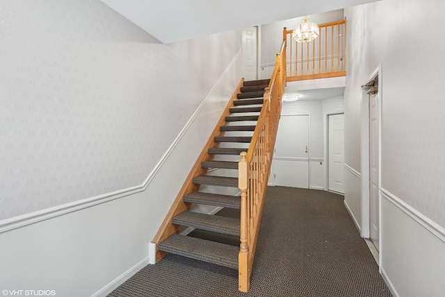 stairs featuring carpet flooring and an inviting chandelier