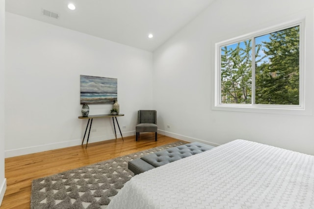 bedroom with hardwood / wood-style floors and vaulted ceiling