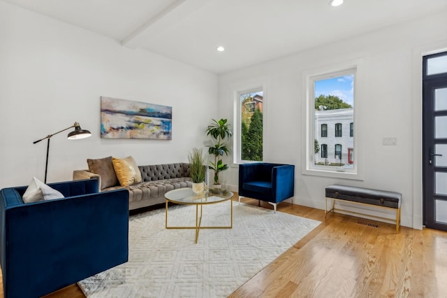 living room with wood-type flooring and beam ceiling