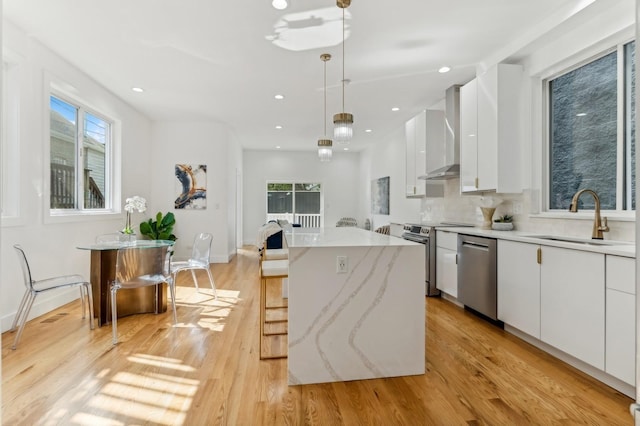 kitchen featuring stainless steel appliances, a kitchen island, pendant lighting, a breakfast bar area, and white cabinets