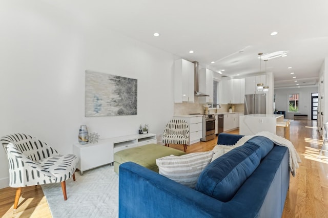 living room with sink and light hardwood / wood-style floors