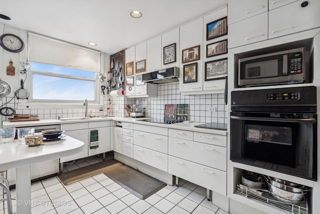 kitchen featuring white cabinets, sink, tasteful backsplash, and black appliances