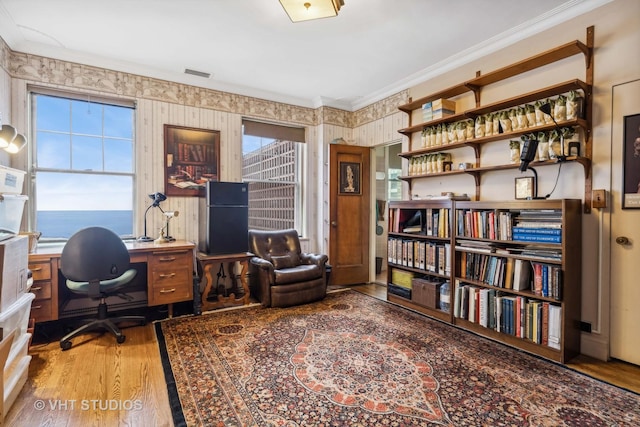 office area featuring hardwood / wood-style floors, a water view, and crown molding