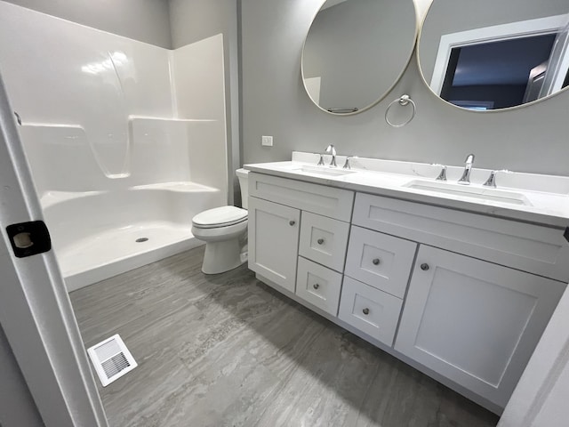 bathroom with vanity, toilet, and a shower