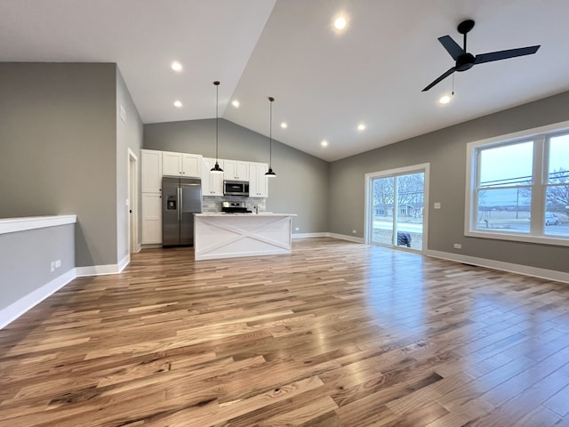 unfurnished living room featuring ceiling fan, light hardwood / wood-style flooring, and lofted ceiling