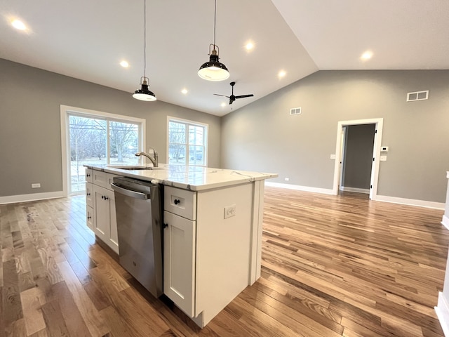 kitchen with a center island with sink, white cabinets, stainless steel dishwasher, ceiling fan, and light stone countertops