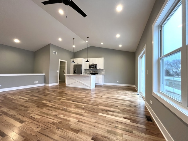 unfurnished living room with ceiling fan, light hardwood / wood-style floors, and high vaulted ceiling