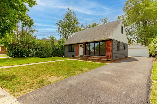 view of front of house with a front yard, a garage, and an outdoor structure