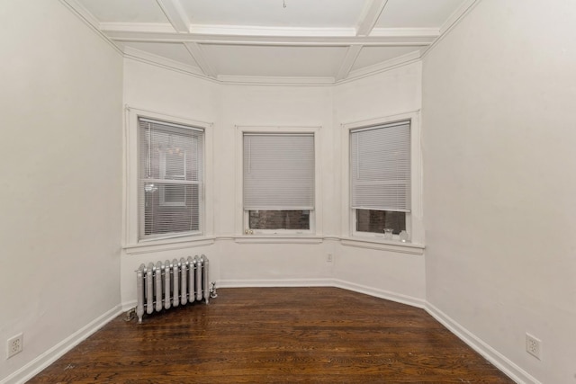 spare room featuring beam ceiling, dark hardwood / wood-style flooring, radiator heating unit, and coffered ceiling