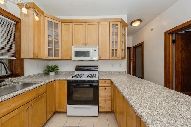 kitchen with white appliances, sink, light stone countertops, light tile patterned floors, and light brown cabinetry