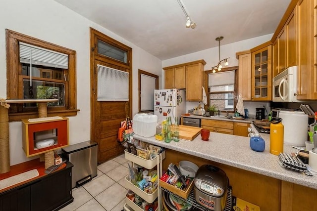 kitchen with kitchen peninsula, white appliances, sink, hanging light fixtures, and light tile patterned flooring