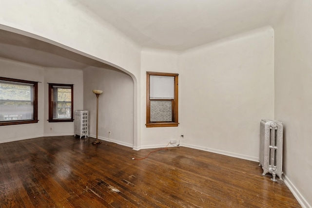 spare room with radiator and dark hardwood / wood-style flooring