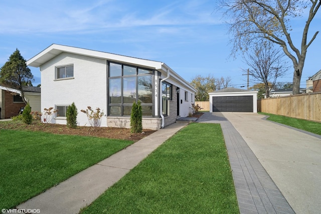 view of front of property featuring a front yard, a garage, and an outdoor structure