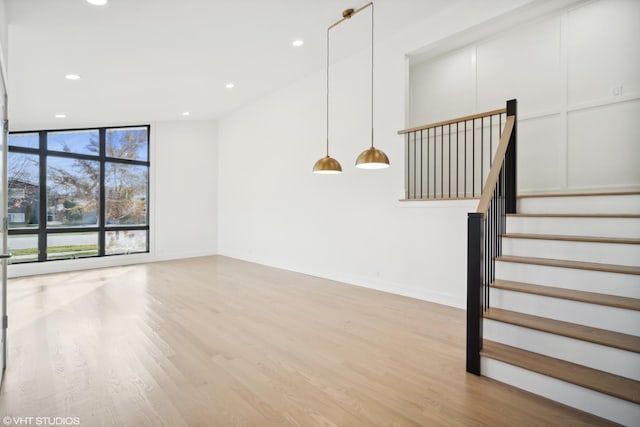 unfurnished living room featuring light hardwood / wood-style flooring and vaulted ceiling