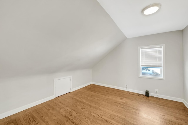 bonus room with hardwood / wood-style floors and vaulted ceiling