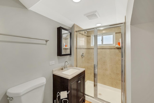 bathroom featuring vanity, an enclosed shower, and toilet