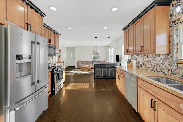 kitchen with backsplash, sink, appliances with stainless steel finishes, decorative light fixtures, and dark hardwood / wood-style flooring