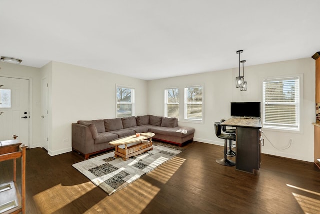 living room featuring dark wood-type flooring and a healthy amount of sunlight