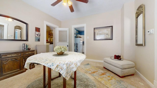 carpeted dining space featuring ceiling fan and separate washer and dryer