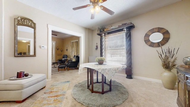 dining room with a textured ceiling, ceiling fan, and light colored carpet